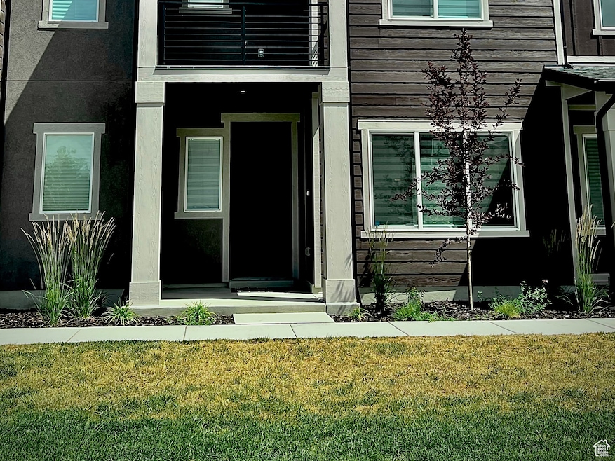 View of front of property with a balcony and a front yard
