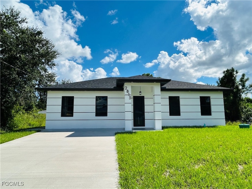 View of front of home with a front yard and concrete driveway