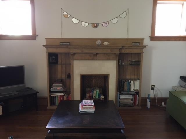 Beautiful ornamental fireplace with flanking bookc