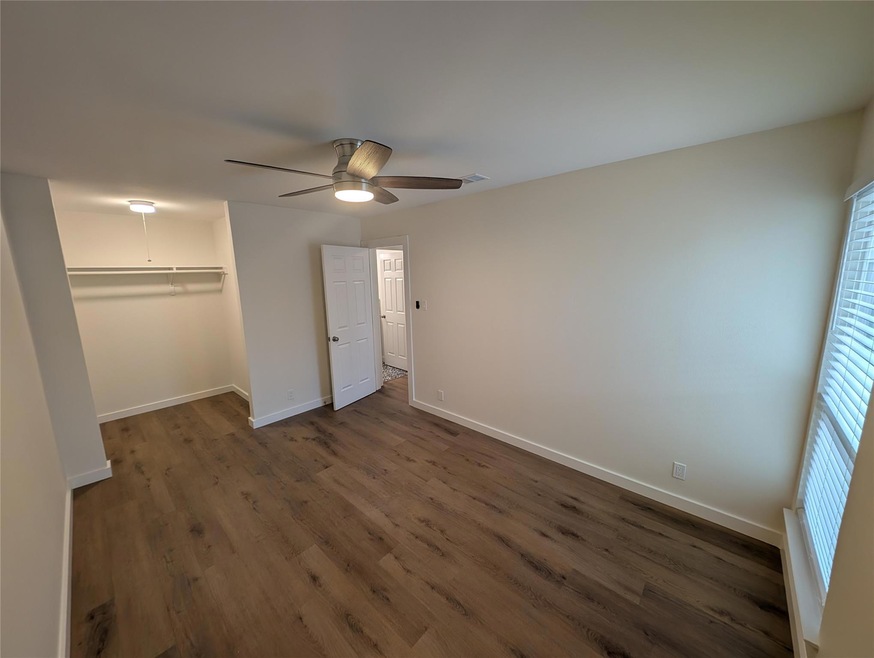 Unfurnished bedroom with dark wood-style flooring
