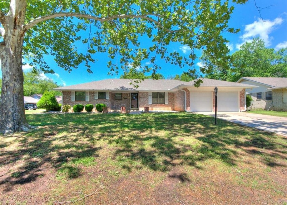 Single story home with a garage and a front yard