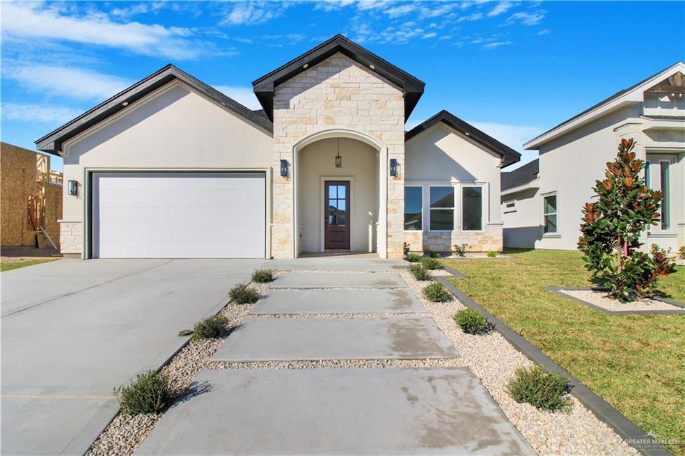 View of front of home featuring stone siding, concrete driveway, stucco siding, and an attached garage