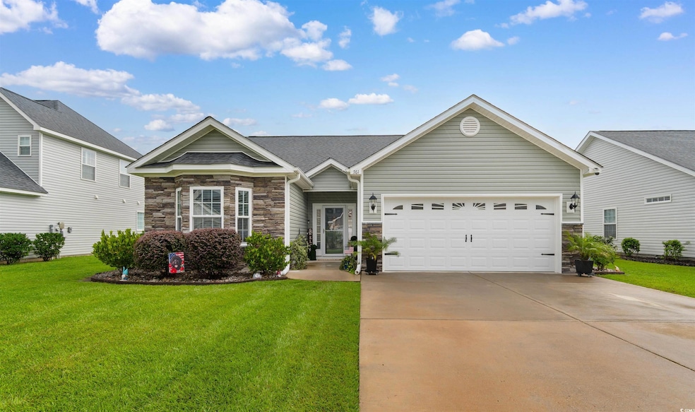 View of front of property with stone siding, a front lawn, an attached garage, and concrete driveway