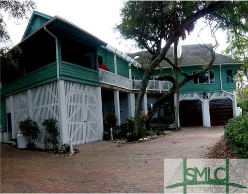 Exterior Front. Acre lot includes mature oaks, bea