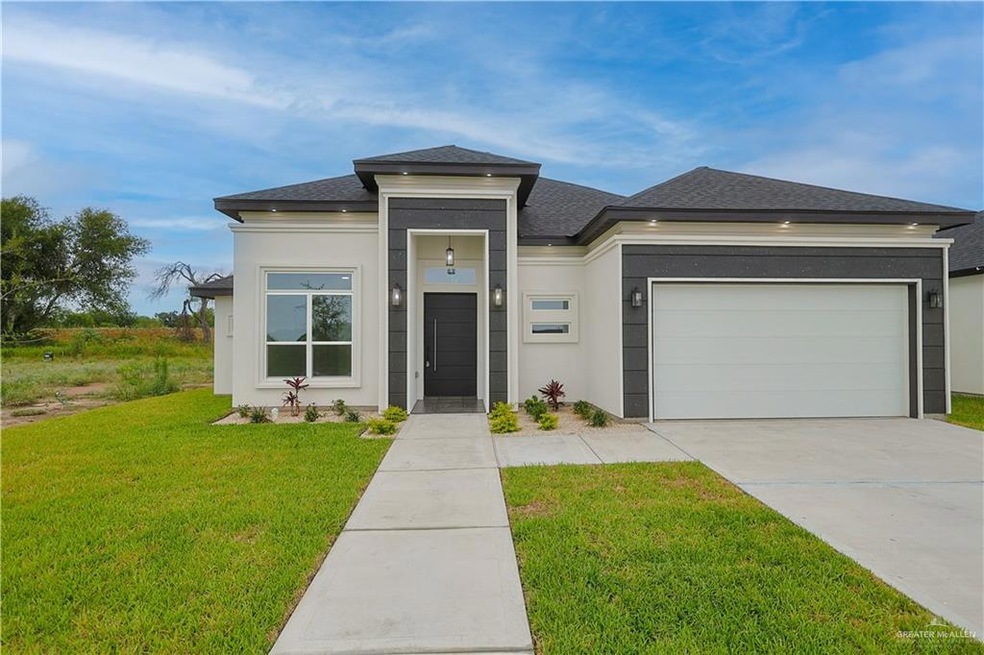 View of front of home featuring a garage and a front lawn