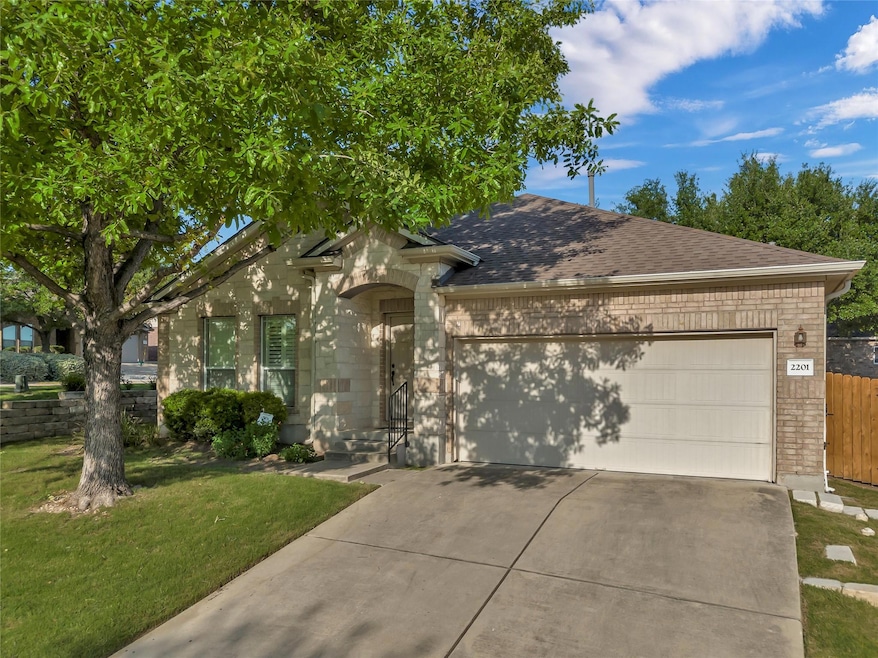 View of front of home featuring driveway, an atta