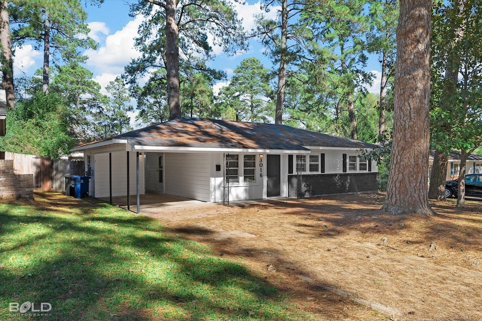 Back of property with a lawn and a carport