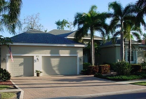 Exterior front. 3 car garage, paver driveway and s
