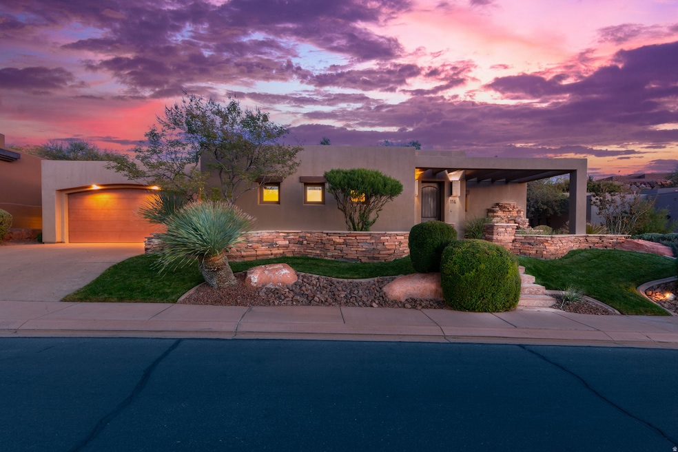 View of front of home with stucco siding, driveway, and an attached garage