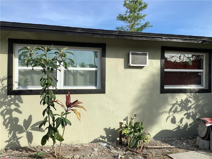 View of front of home featuring stucco and an AC wall unit