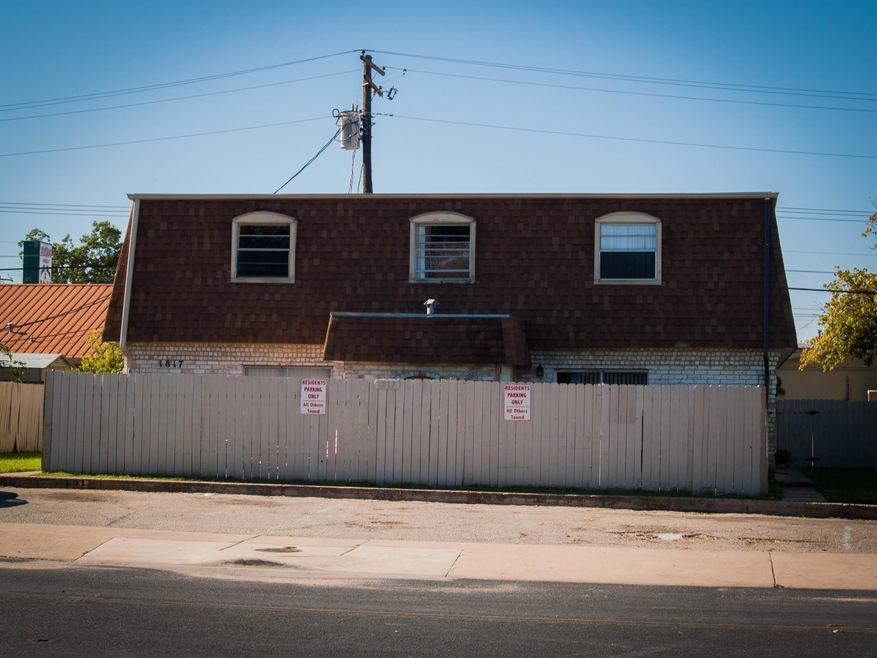 View of front of home featuring mansard roof, bri