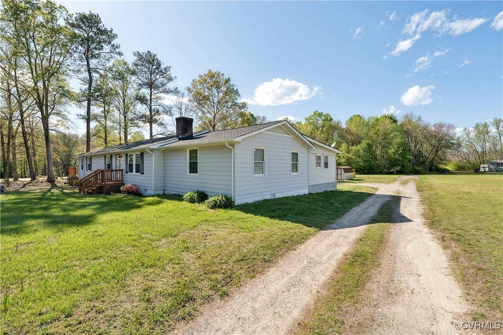 View of side of property with driveway, a chimney,