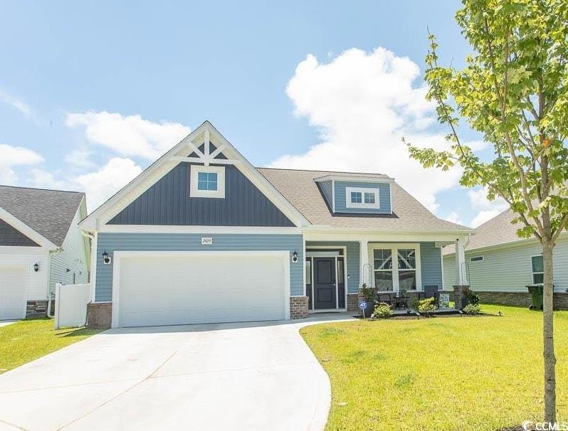 Craftsman inspired home with a front yard, an attached garage, driveway, board and batten siding, and covered porch