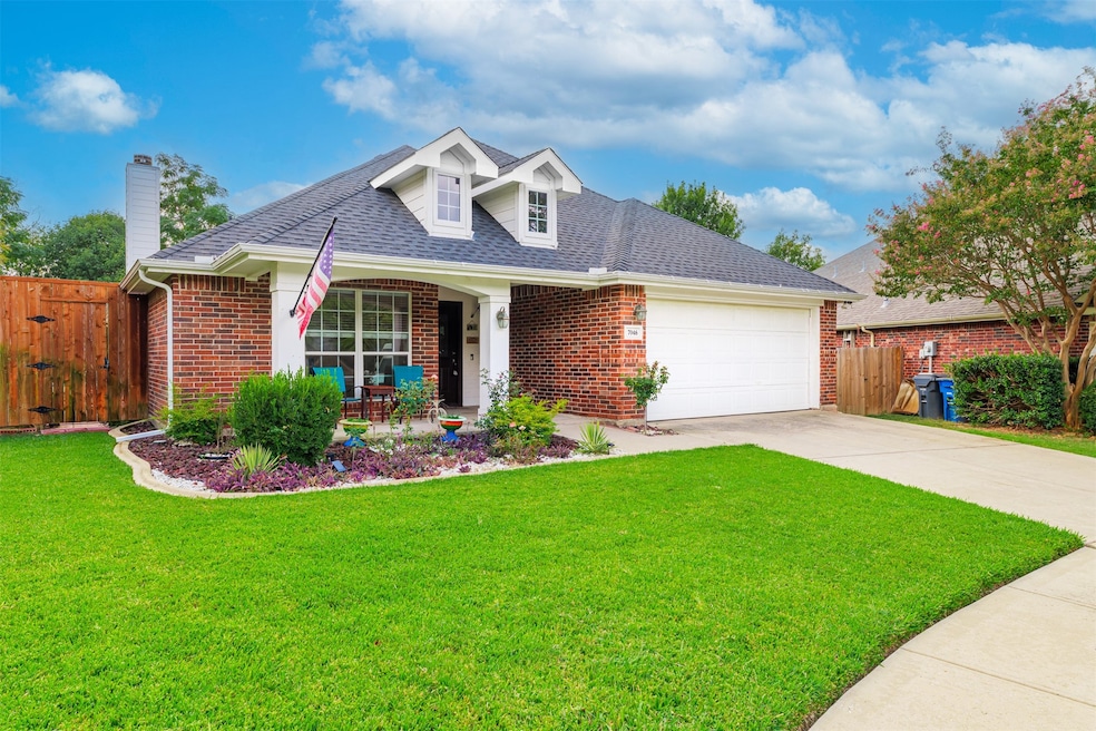 View of front of house with covered porch, brick siding, concrete driveway, roof with shingles, and a chimney
