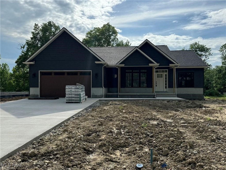 Ranch-style house featuring driveway, an attached garage, and roof with shingles