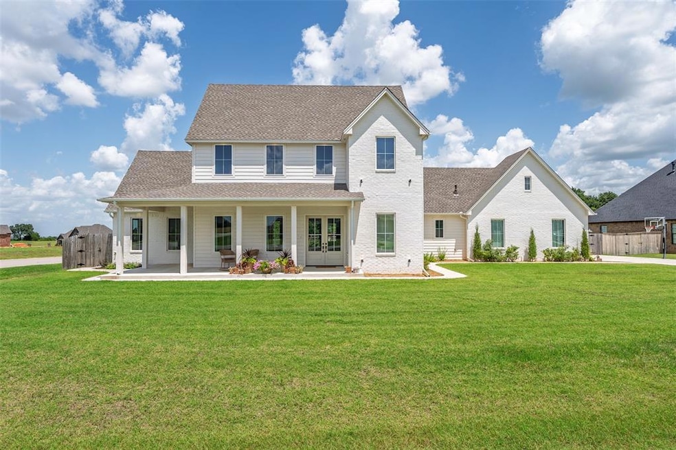 Back of house featuring a shingled roof, french doors, and brick siding