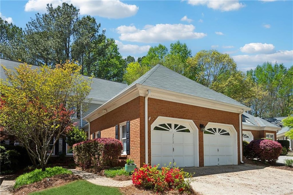 View of home's exterior with 2-car garage. Garage interior leads to courtyard entrance to home. You can also walk through the landscaped path around garage.