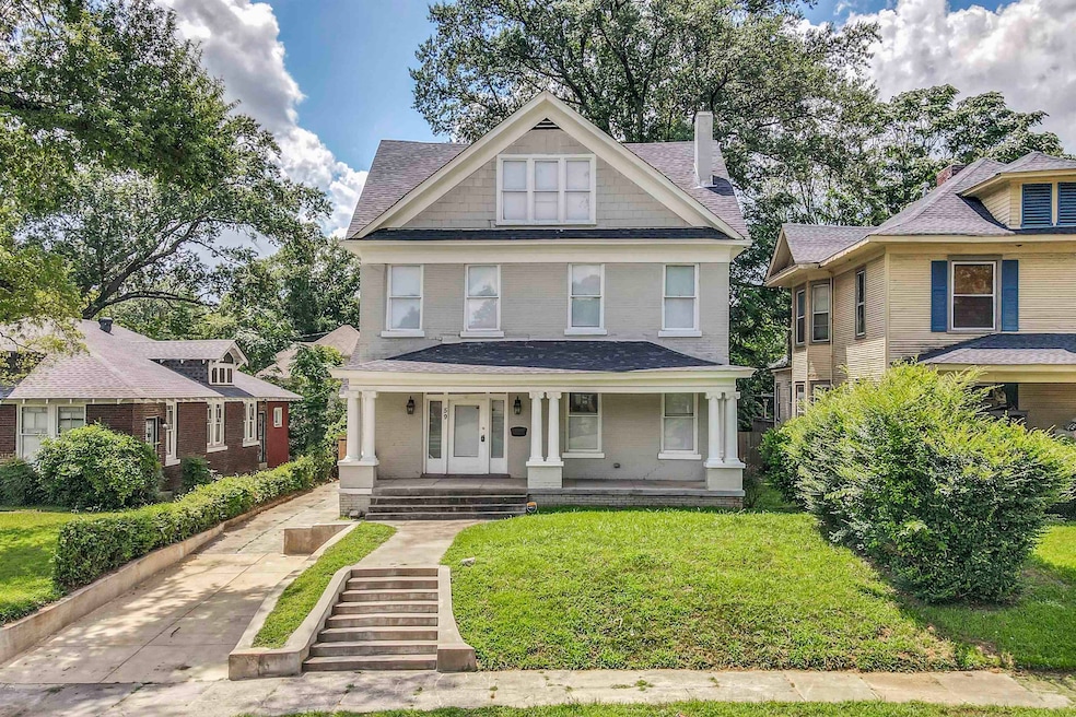 Traditional style home featuring roof with shingles, a porch, a front yard, a chimney, and concrete driveway