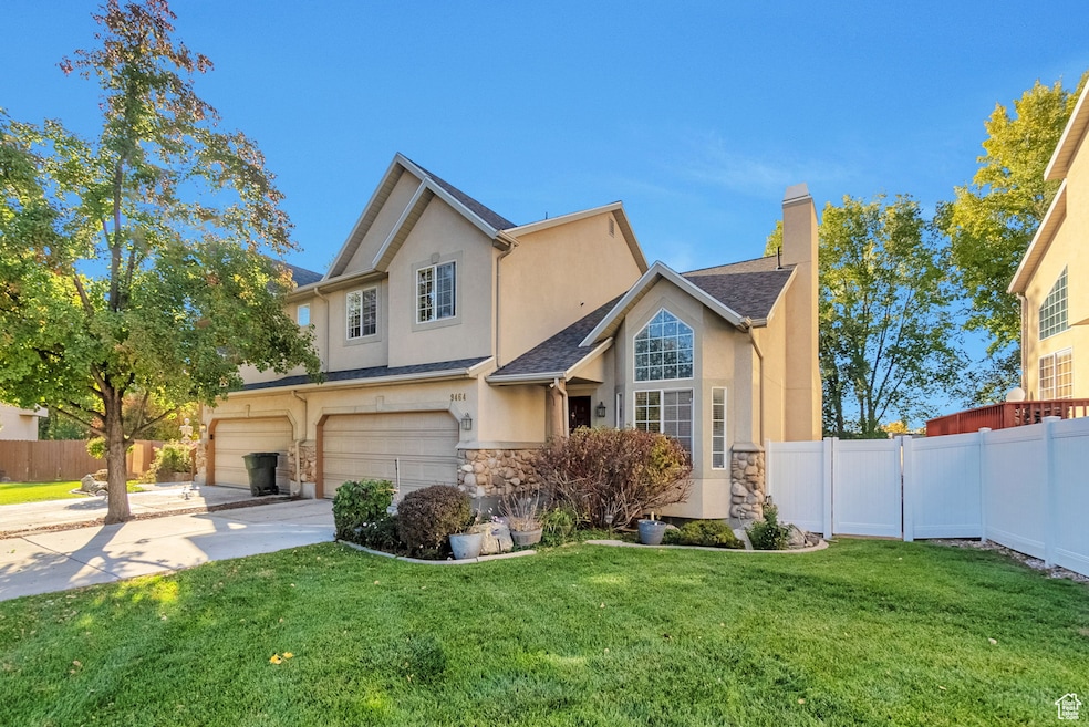 Traditional home with stucco siding, a garage, a chimney, and driveway