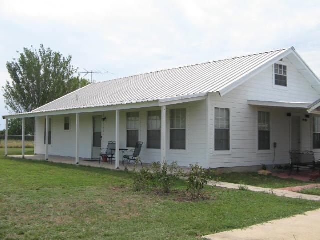 View of front of home featuring a front lawn, a m