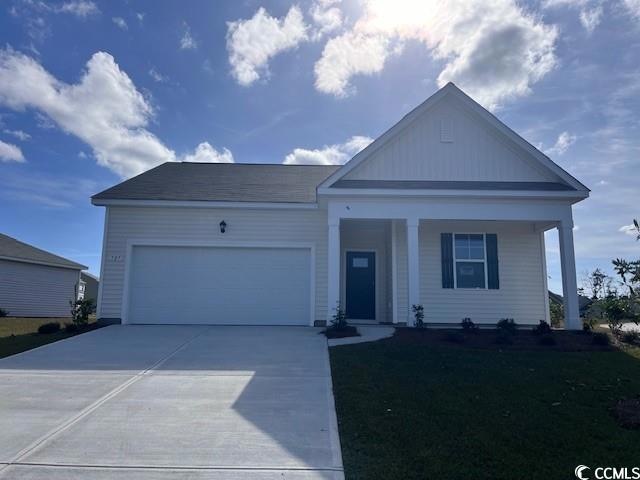 View of front facade with a garage and covered por