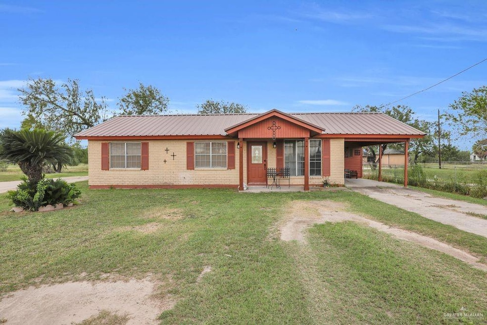 Single story home featuring driveway, covered porch, a metal roof, and a carport