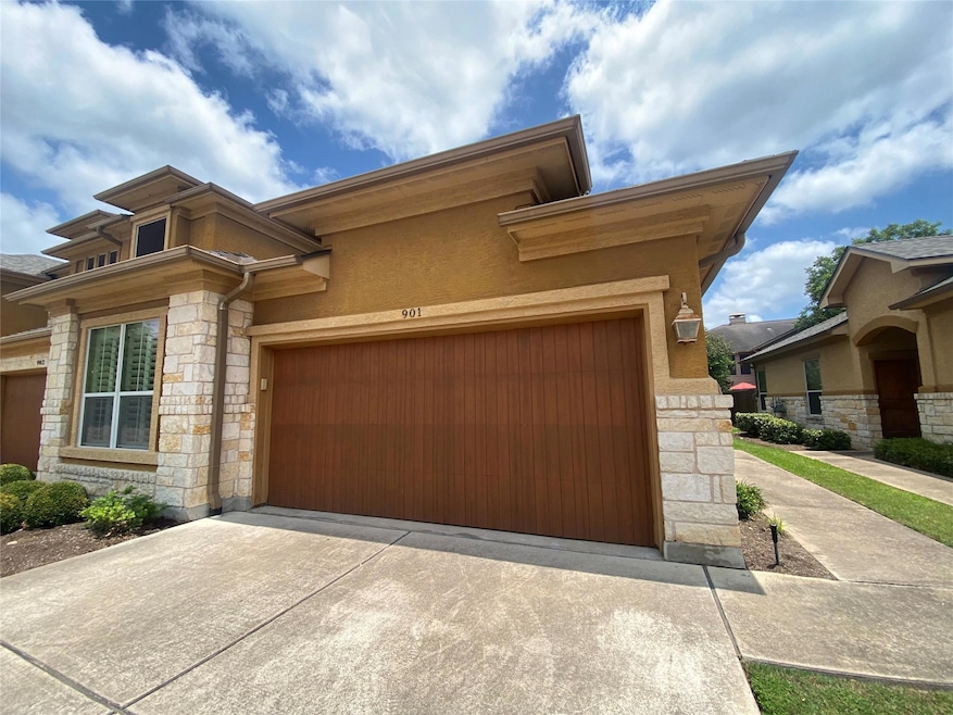 View of front of house with stone siding, drivewa