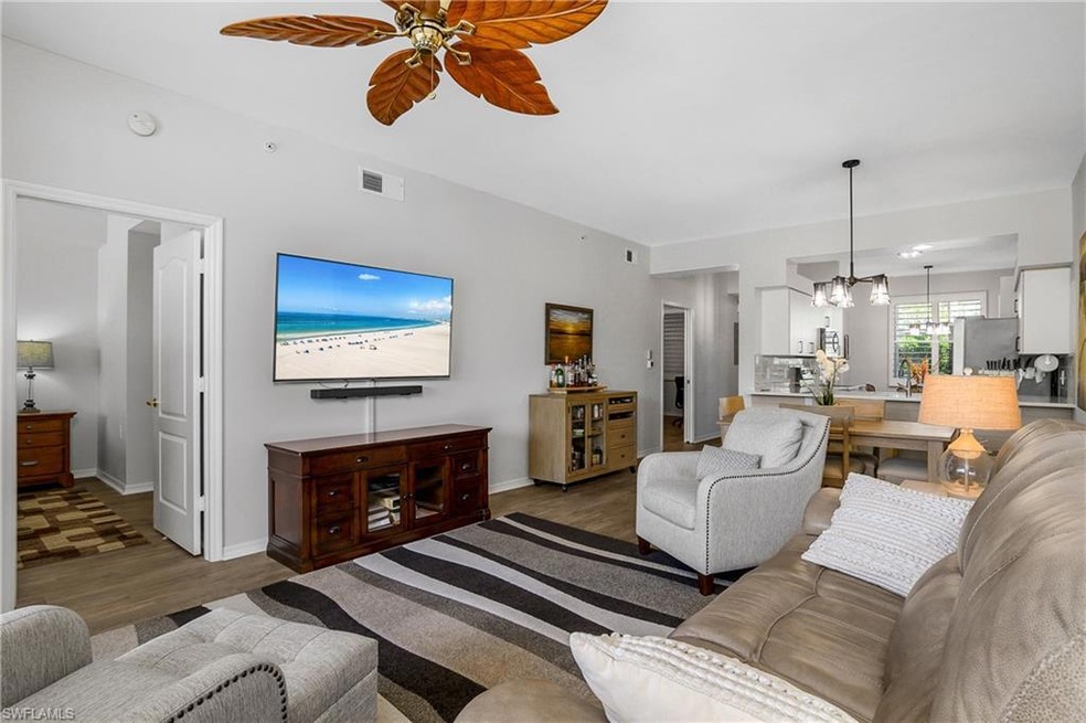 Living area featuring a chandelier, wood finished floors, and a ceiling fan