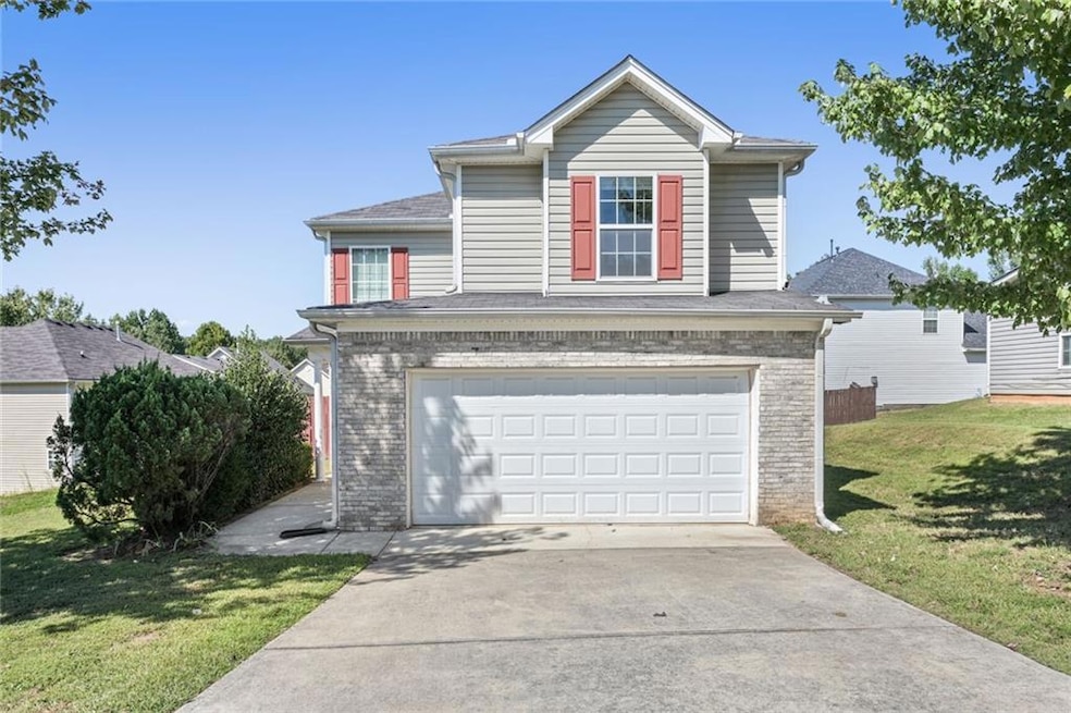 Traditional-style home with driveway, a garage, a front lawn, and brick siding