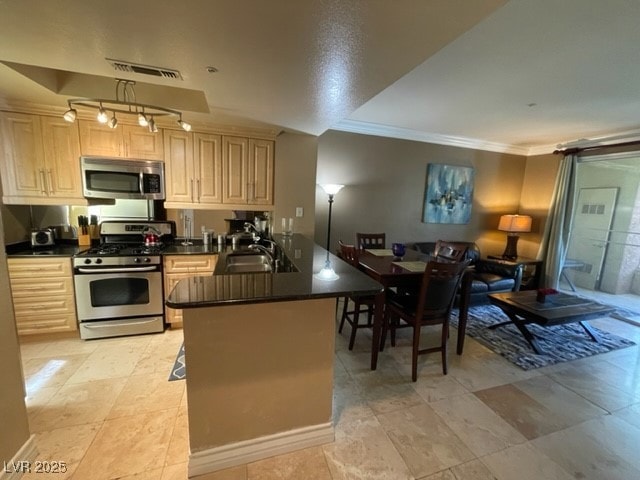 Kitchen with a sink, dark countertops, visible ven