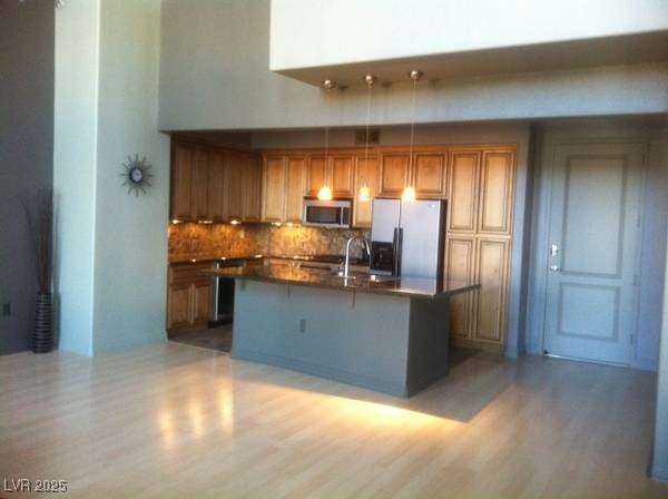 Kitchen with dark countertops, brown cabinetry, li