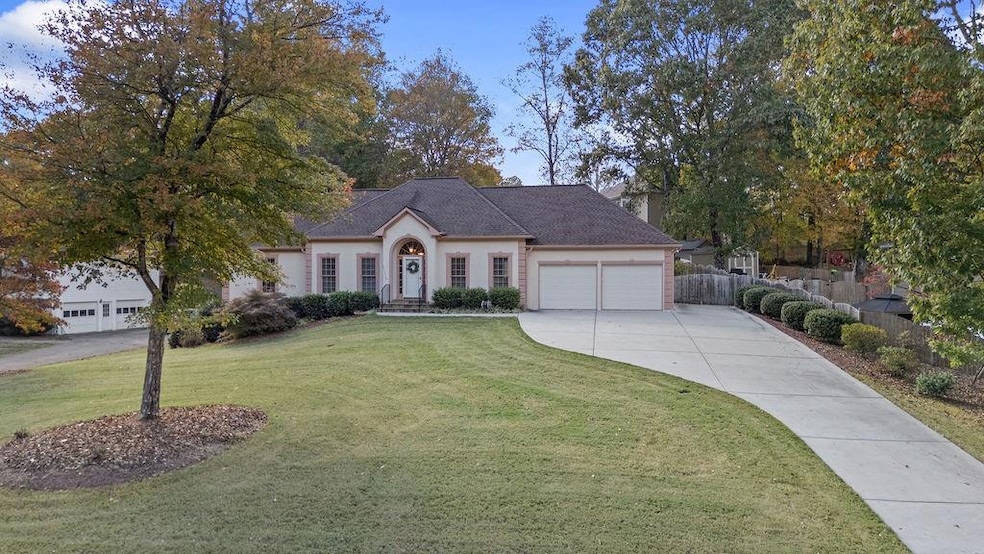 View of front facade featuring driveway, an attached garage, stucco siding, and a shingled roof