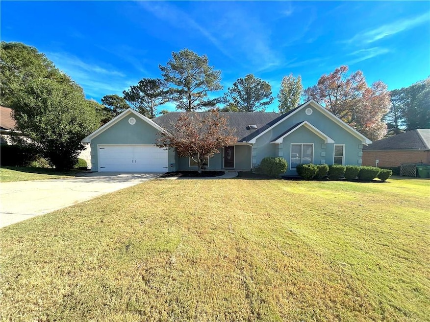 Ranch-style home featuring a front yard and a garage