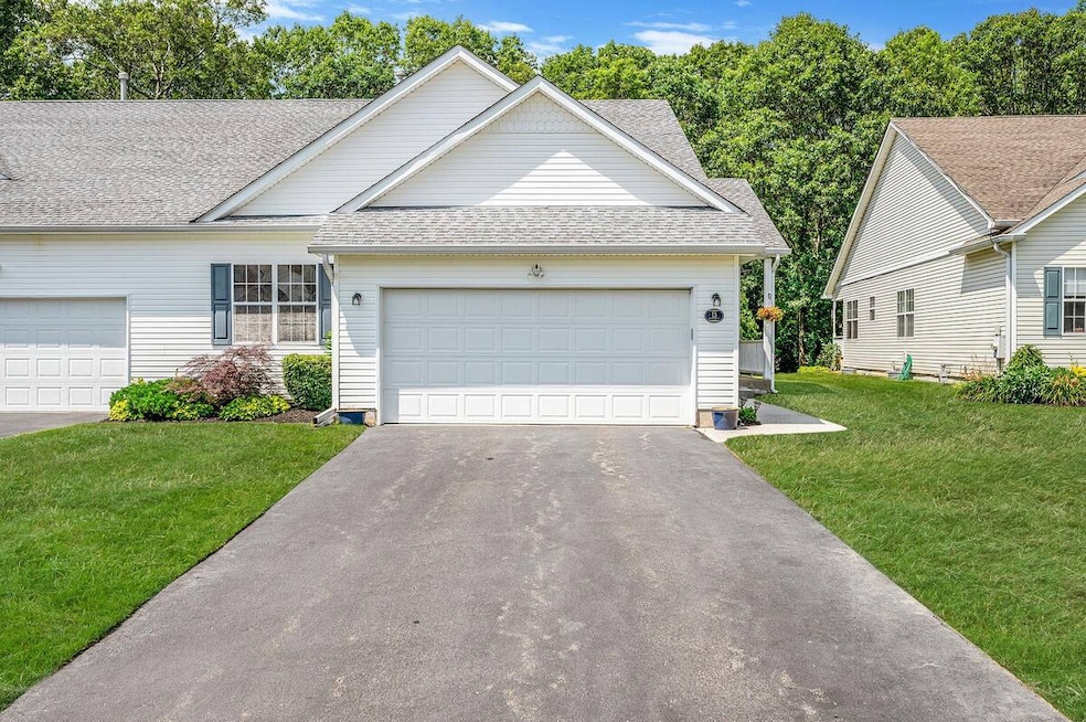 Traditional-style home with roof with shingles, driveway, a front lawn, and a garage