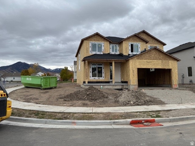 Unfinished property with a porch, a mountain view, and driveway