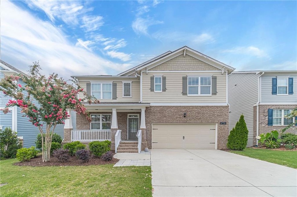 Craftsman-style home with a garage, a front lawn, and covered porch