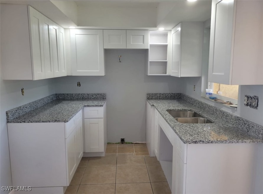 Kitchen with light stone countertops, white cabine