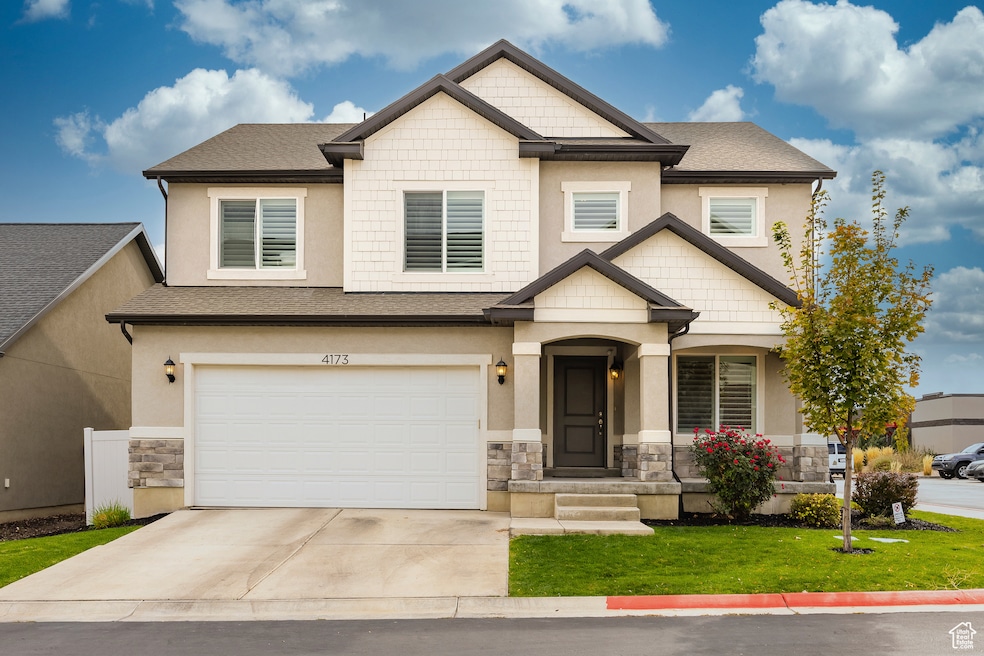 Craftsman house featuring stone siding, a garage, stucco siding, driveway, and a front yard