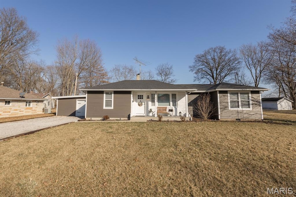 Ranch-style home with a front lawn, a chimney, and an outbuilding