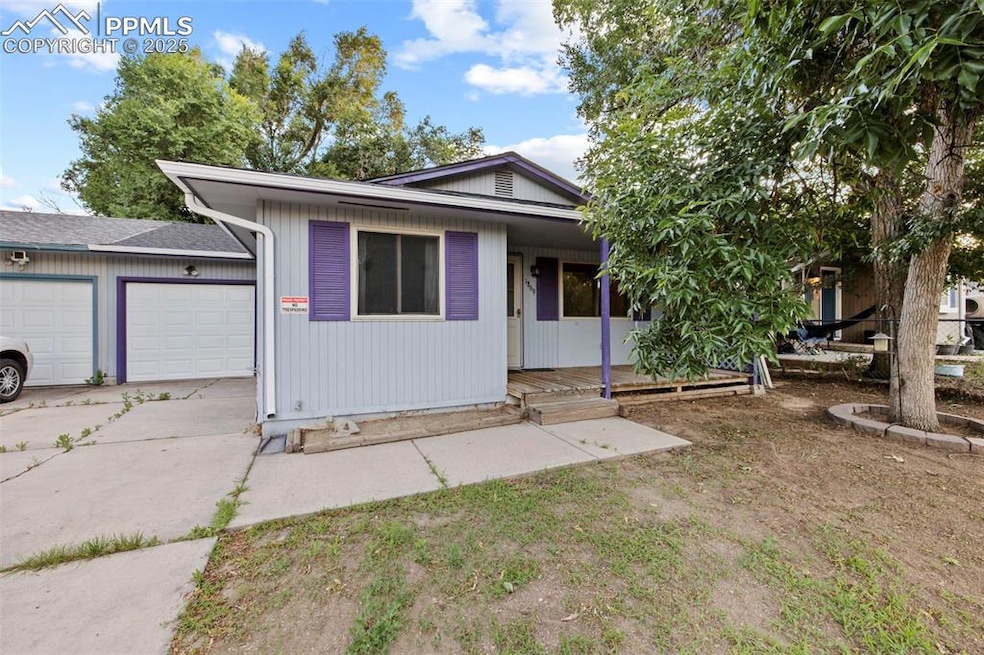 View of front of home featuring a garage, concrete driveway, and a porch
