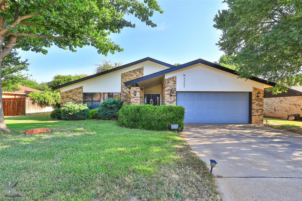 Ranch-style home with a garage and a front lawn