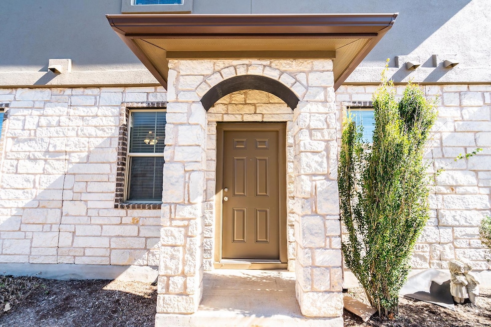 Entrance to property featuring stone siding