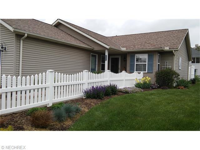 Cute picket fence and beautiful flower beds.