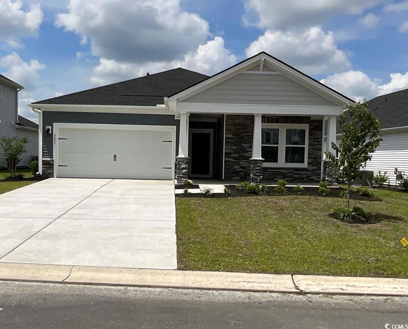 Craftsman house with stone siding, driveway, a gar