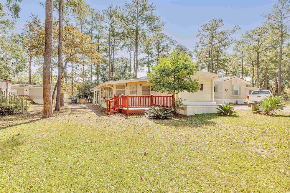 Back of property with a deck and a lawn