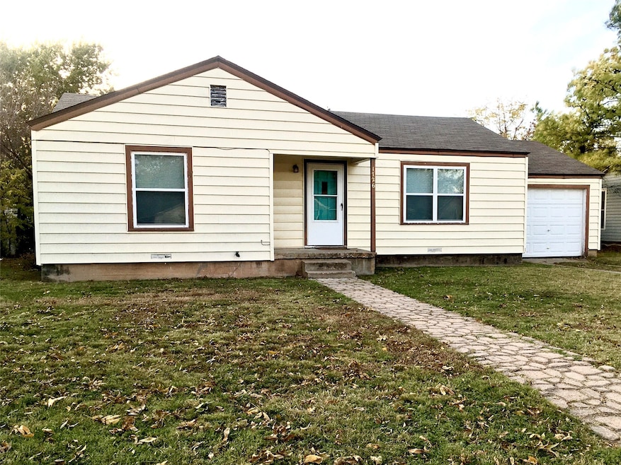 View of front of home with a front yard, roof with shingles, and crawl space