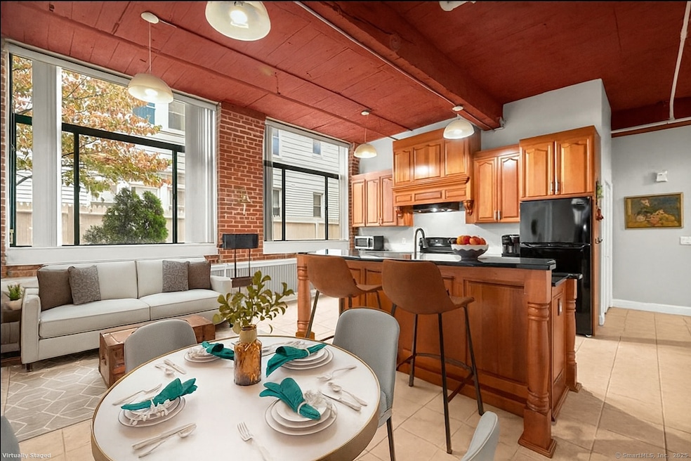 The open main living area includes a massive Eat-in kitchen with tall solid wood cabinetry, granite countertops including beveled dish-dry edge, large center island with bar-height seating, pantry, electric oven/range, vent hood, newer dishwasher, re