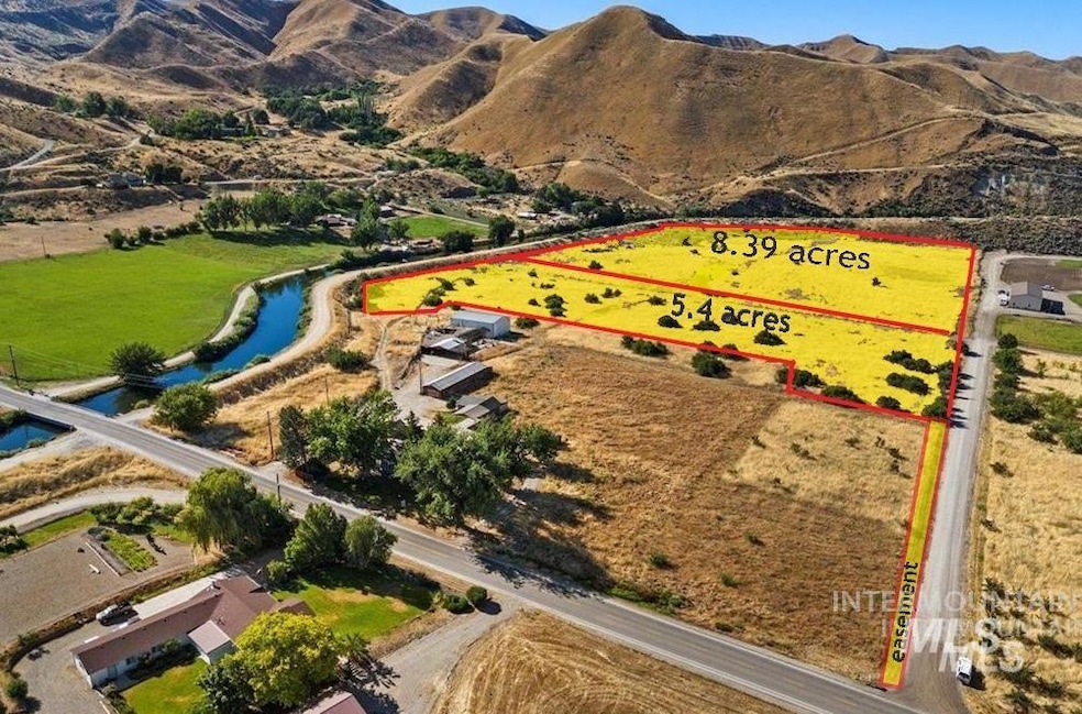Aerial view of property and surrounding area with property parcel outlined and a mountain backdrop