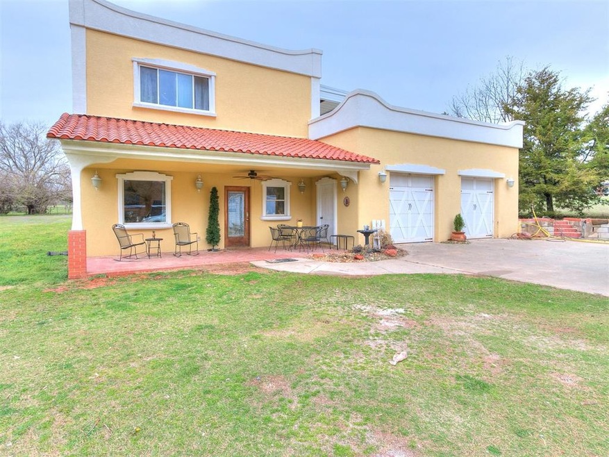 View of front of property featuring a garage, a front yard, a patio, and ceiling fan
