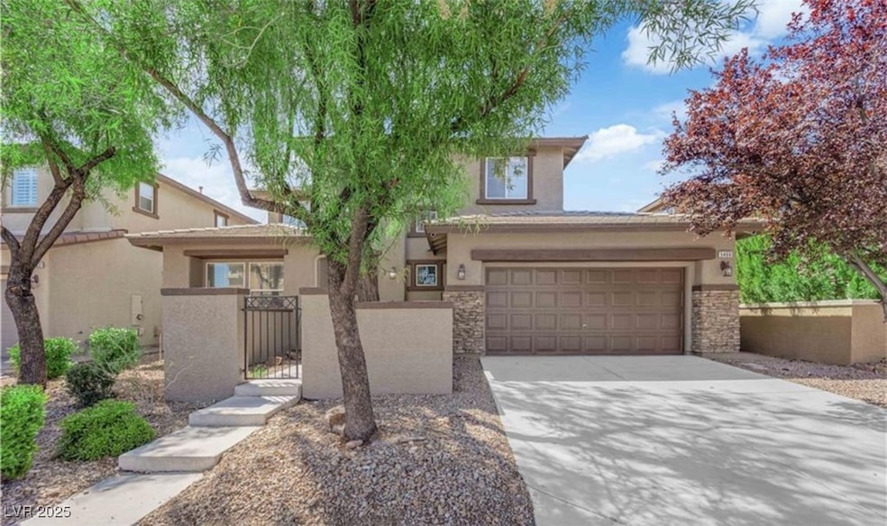 View of front of home with a fenced front yard, concrete driveway, stucco siding, and a gate